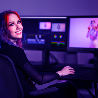 woman smiling at computer gaming with twitch overlays